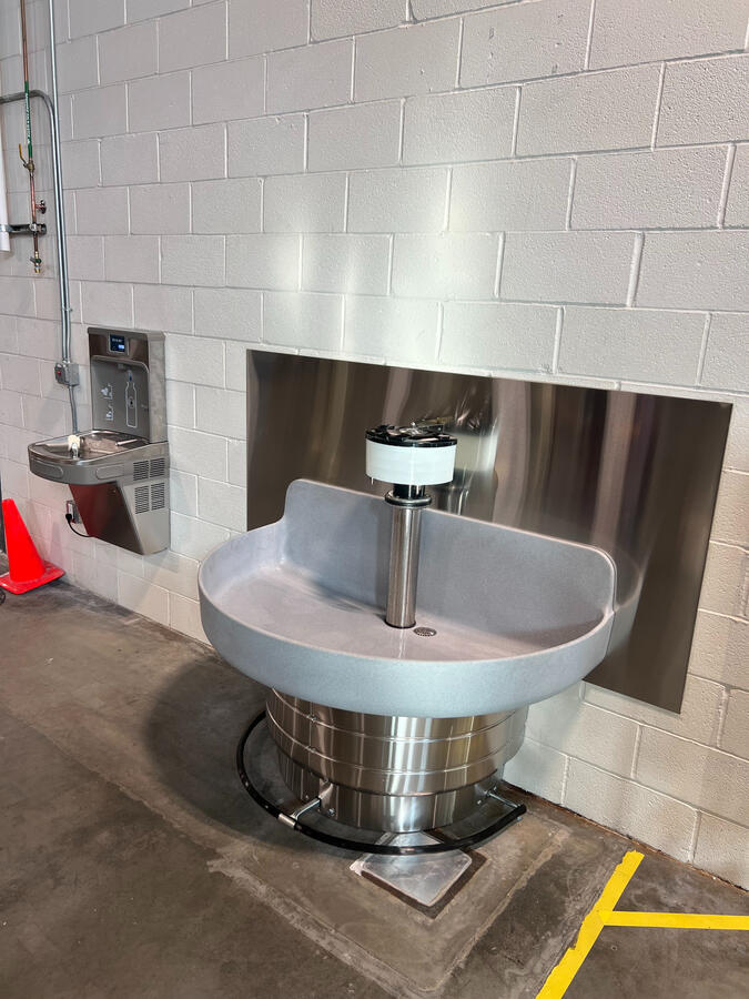 Commercial-grade stainless steel handwashing station with plumbing connections