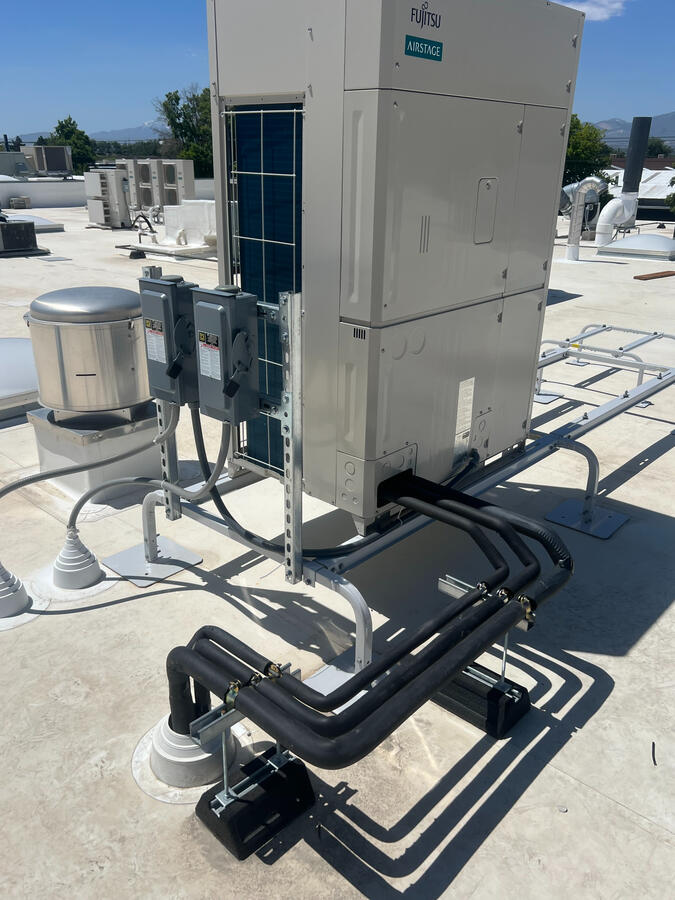 VRF outdoor unit connected to piping system on commercial rooftop