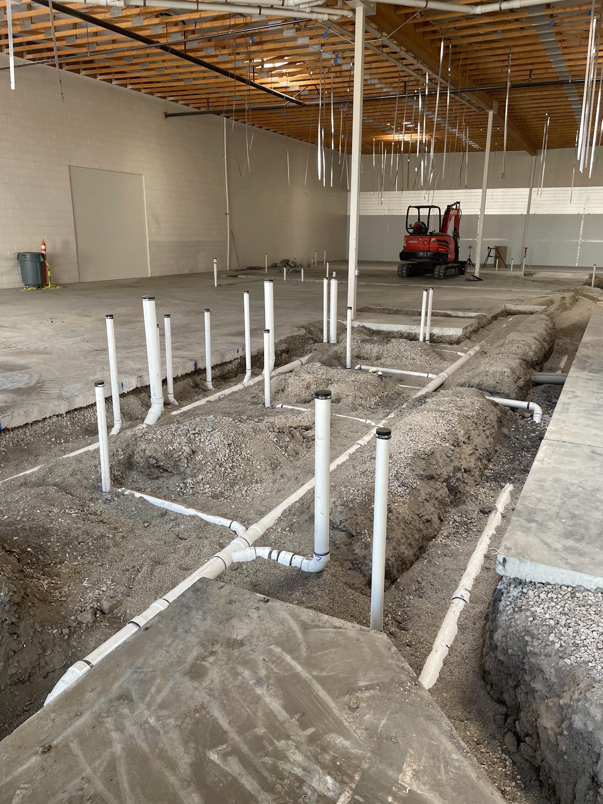 Industrial building interior with exposed trench and PVC piping installed by Deseret Peak Piping